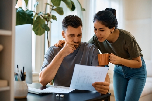 A man and woman looking over and discussing their energy bills.